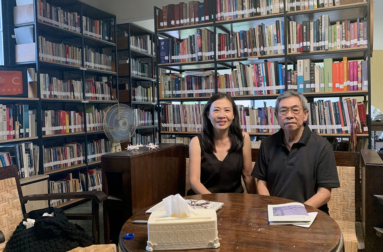 Rozana sitting with artists FX Harsono in a library