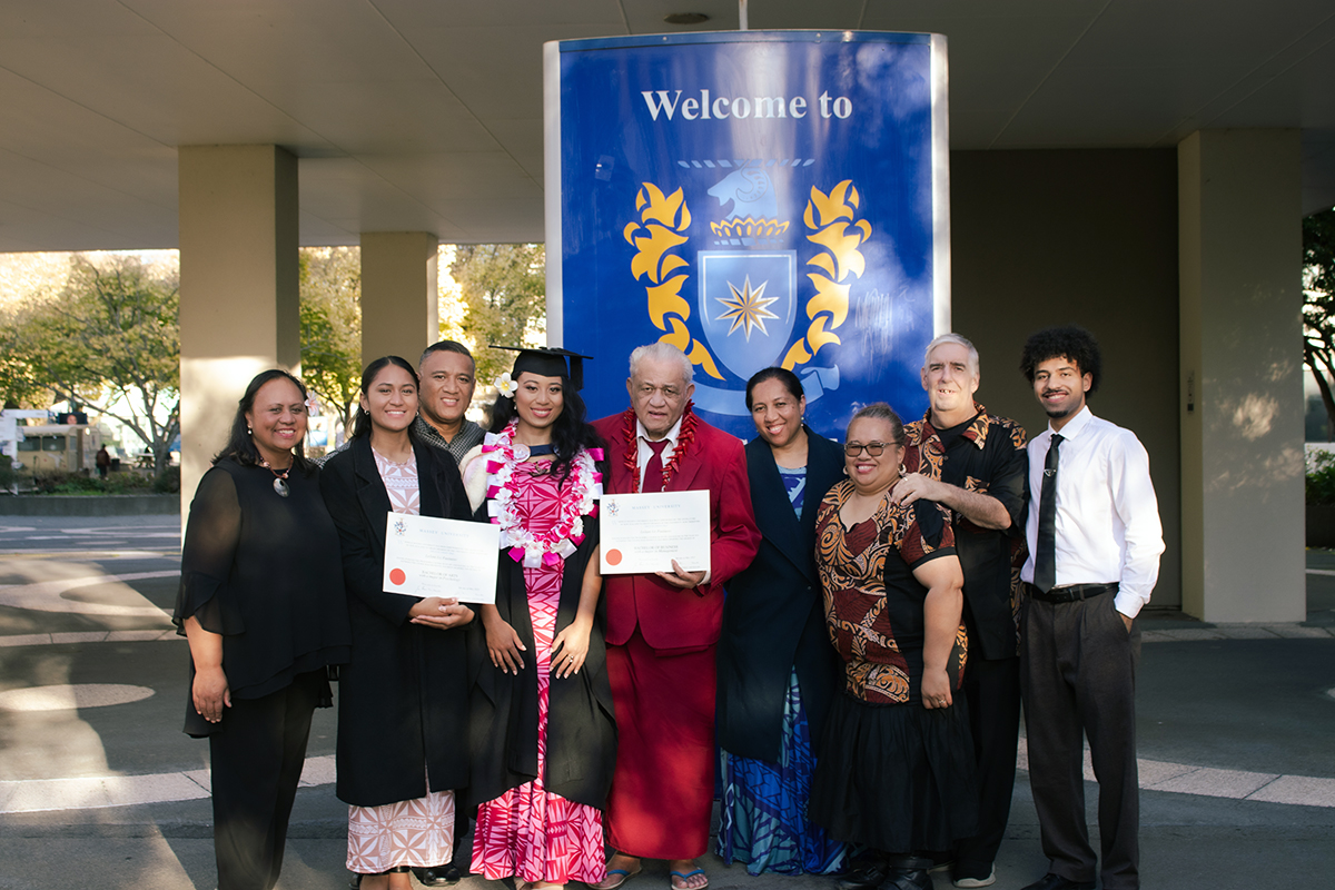Leilani in her graduation gown standing with a family group