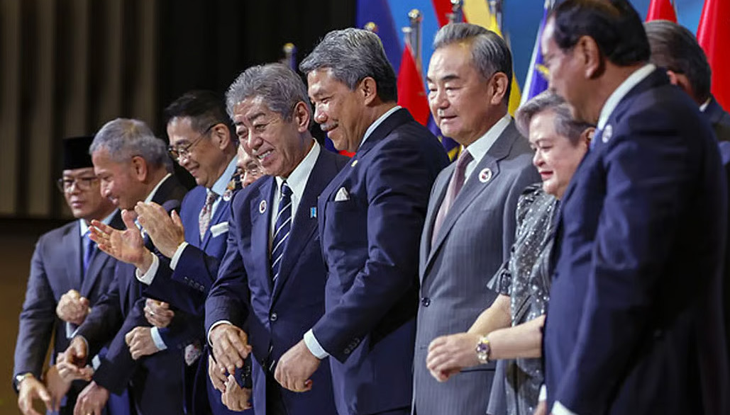 Foreign ministers of China, Japan and South Korea with Malaysian foreign minister Mohamad Hasan staning on stage in front of their national flags