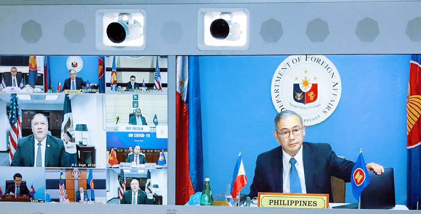 Foreign Affairs Secretary Teodoro L. Locsin Jr. sitting at a desk next to the ASEAN and Philippines flags