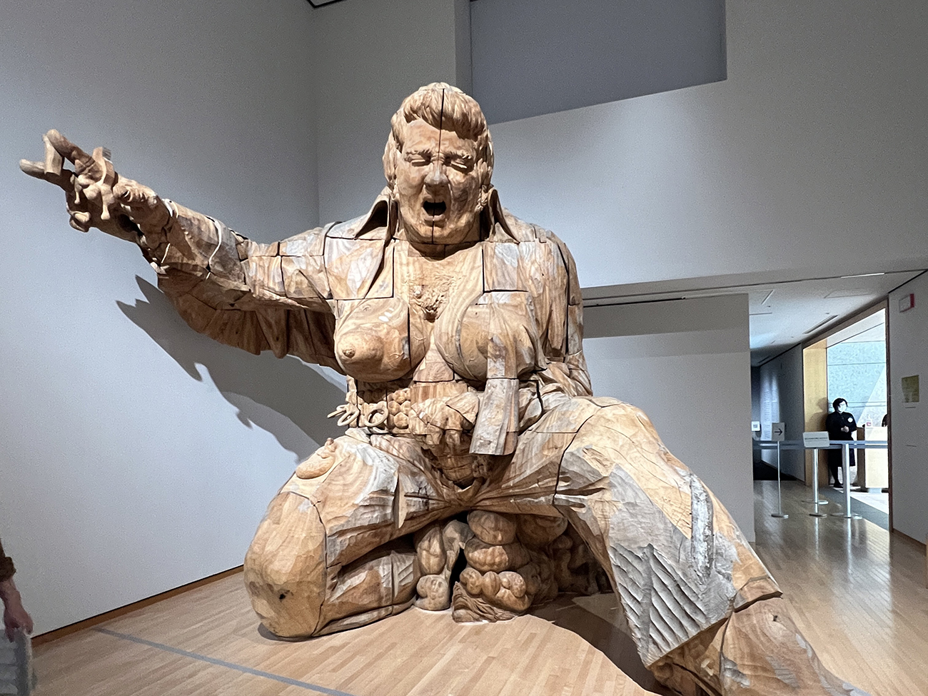 A large wood scylpture of an Elvis-like figure with breasts