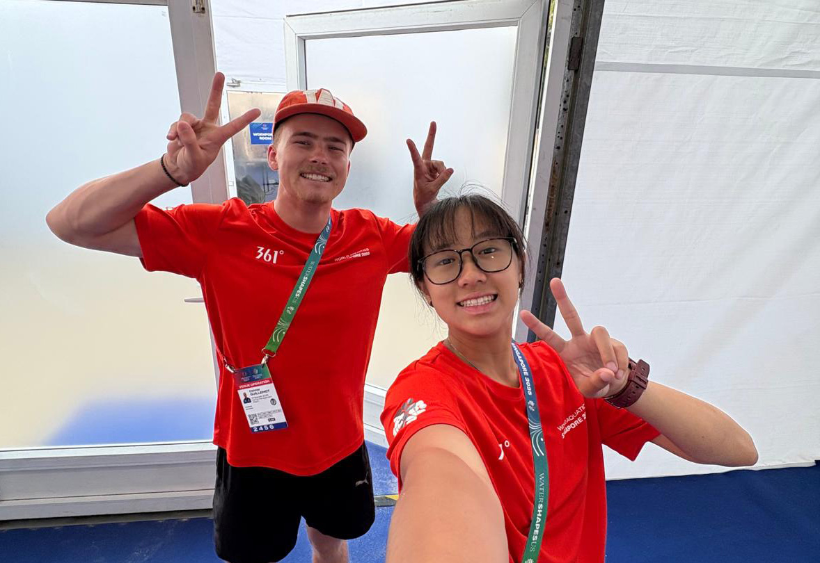 Conar and a fellow intern posing for a selfie in their red World Aquatics Championships  t-shirts