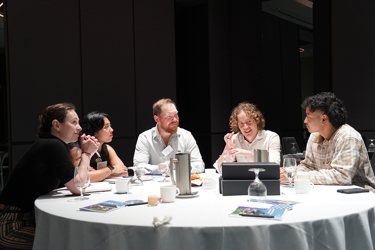 Five new members sitting at a table chatting
