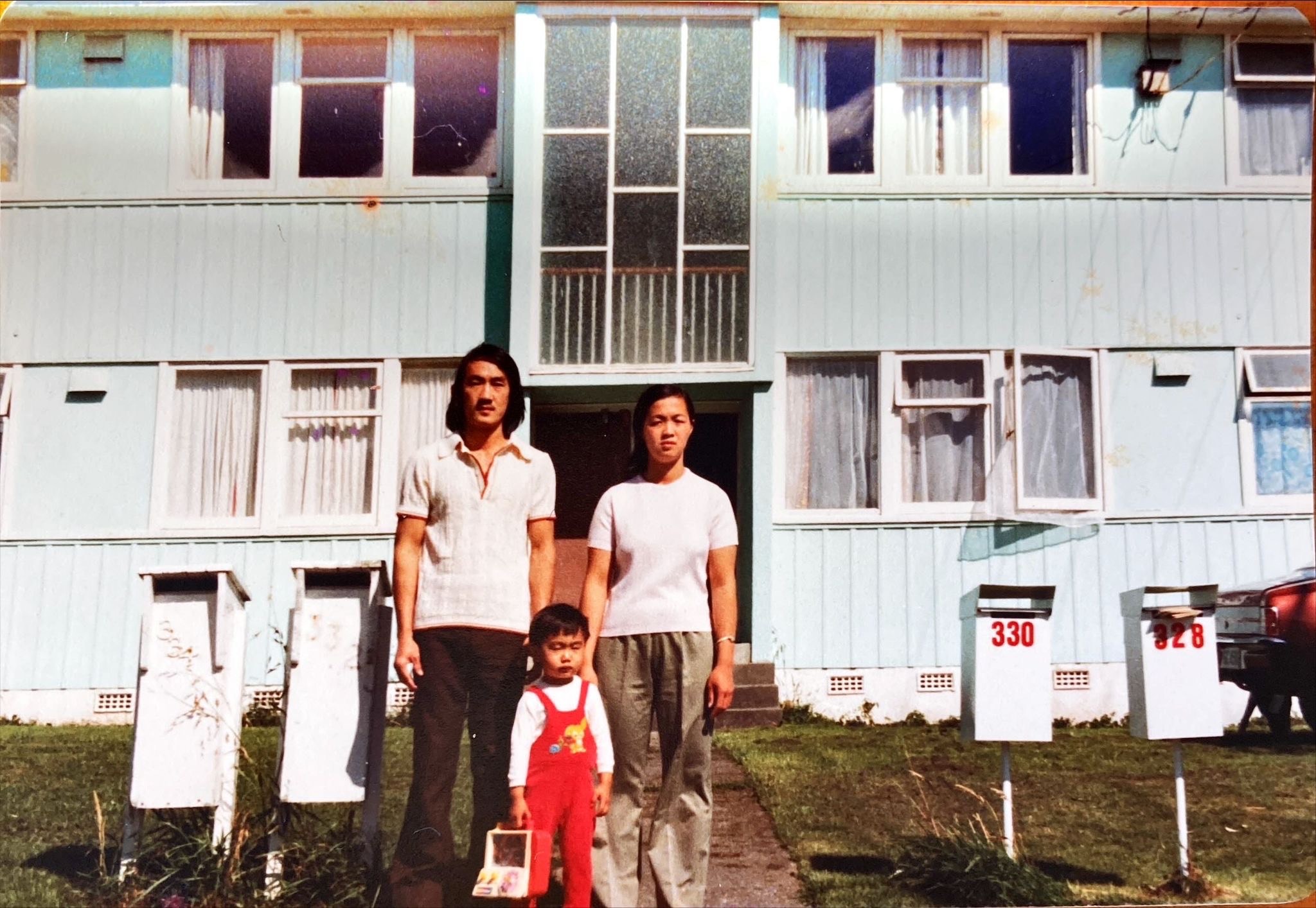 Lingy's parents with his older brother (aged about three) in front of their state house in 1979
