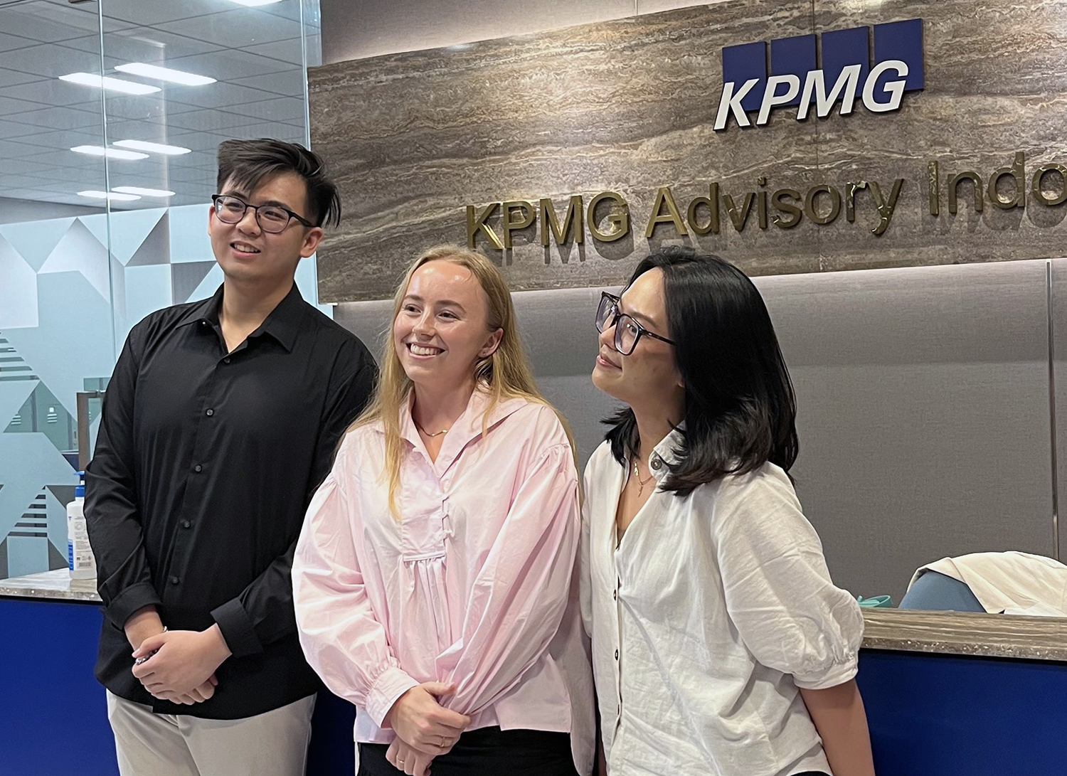 Olivia posing for a photo with two KMPG staff