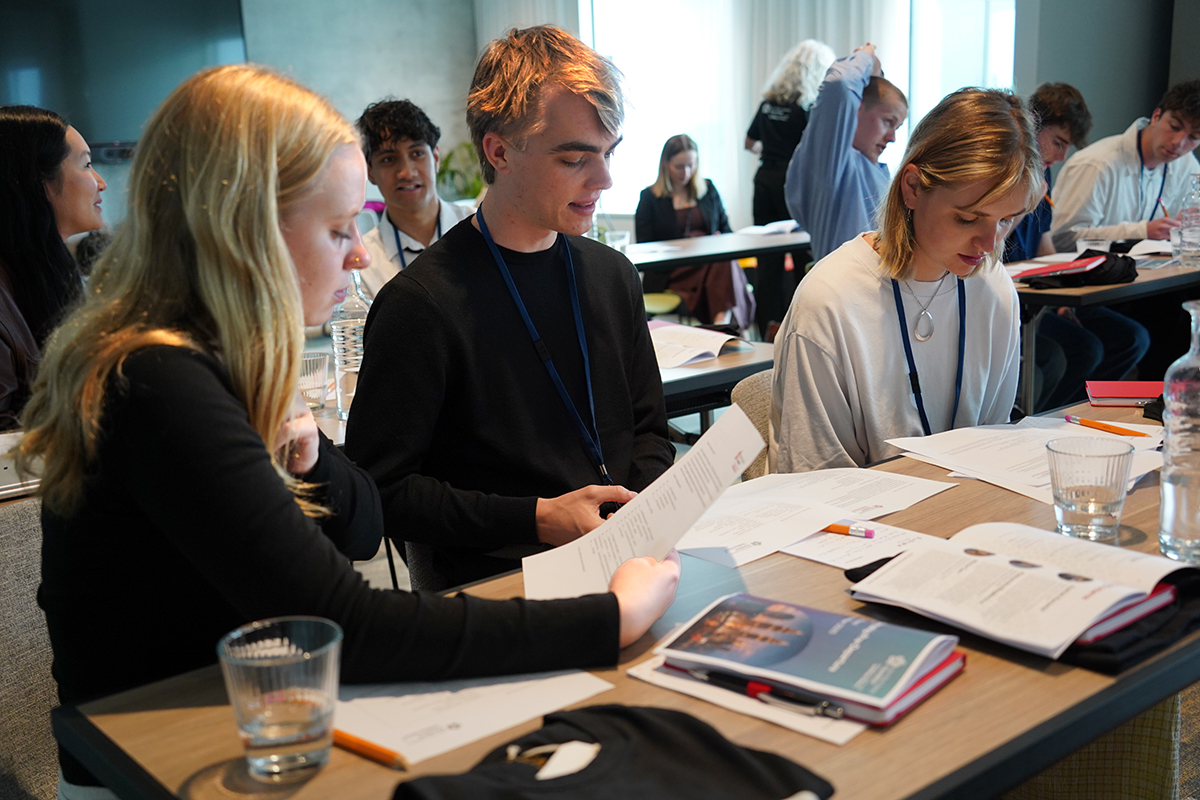 Interns sitting at desks reading from documents