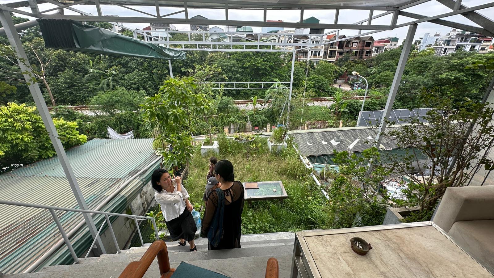 Two people chatrting on steps overlooking a garden