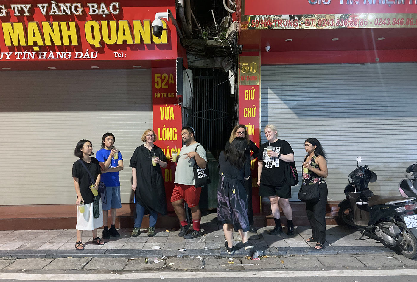 A group of eight people chatting outside closed shops at night