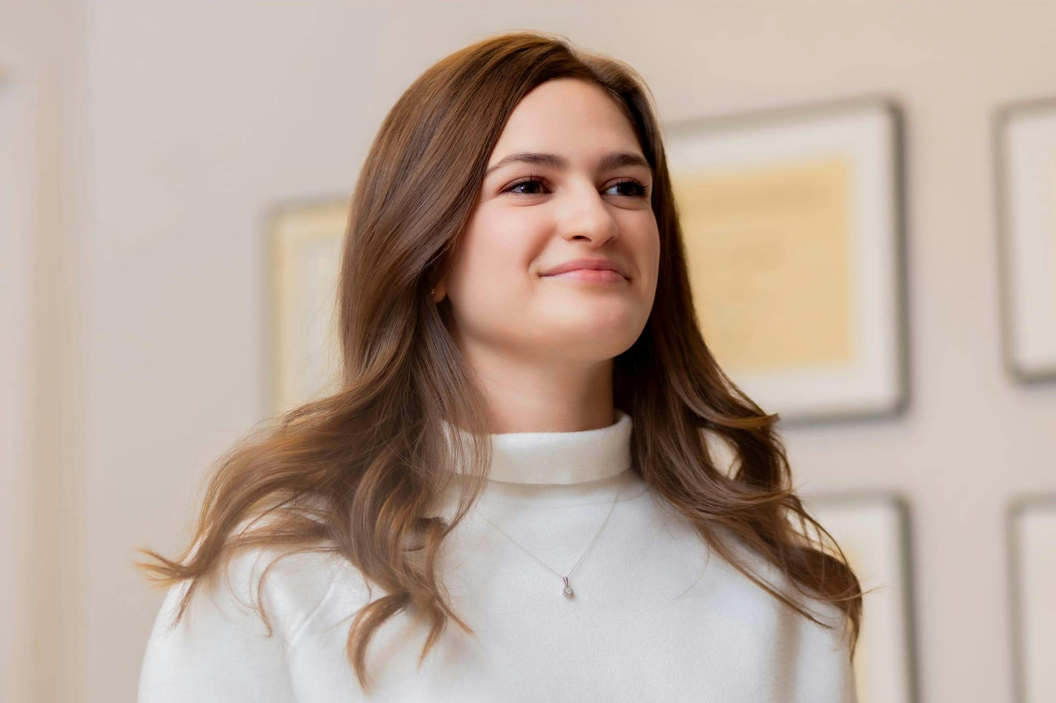 Woman in a white turtle neck, smiling