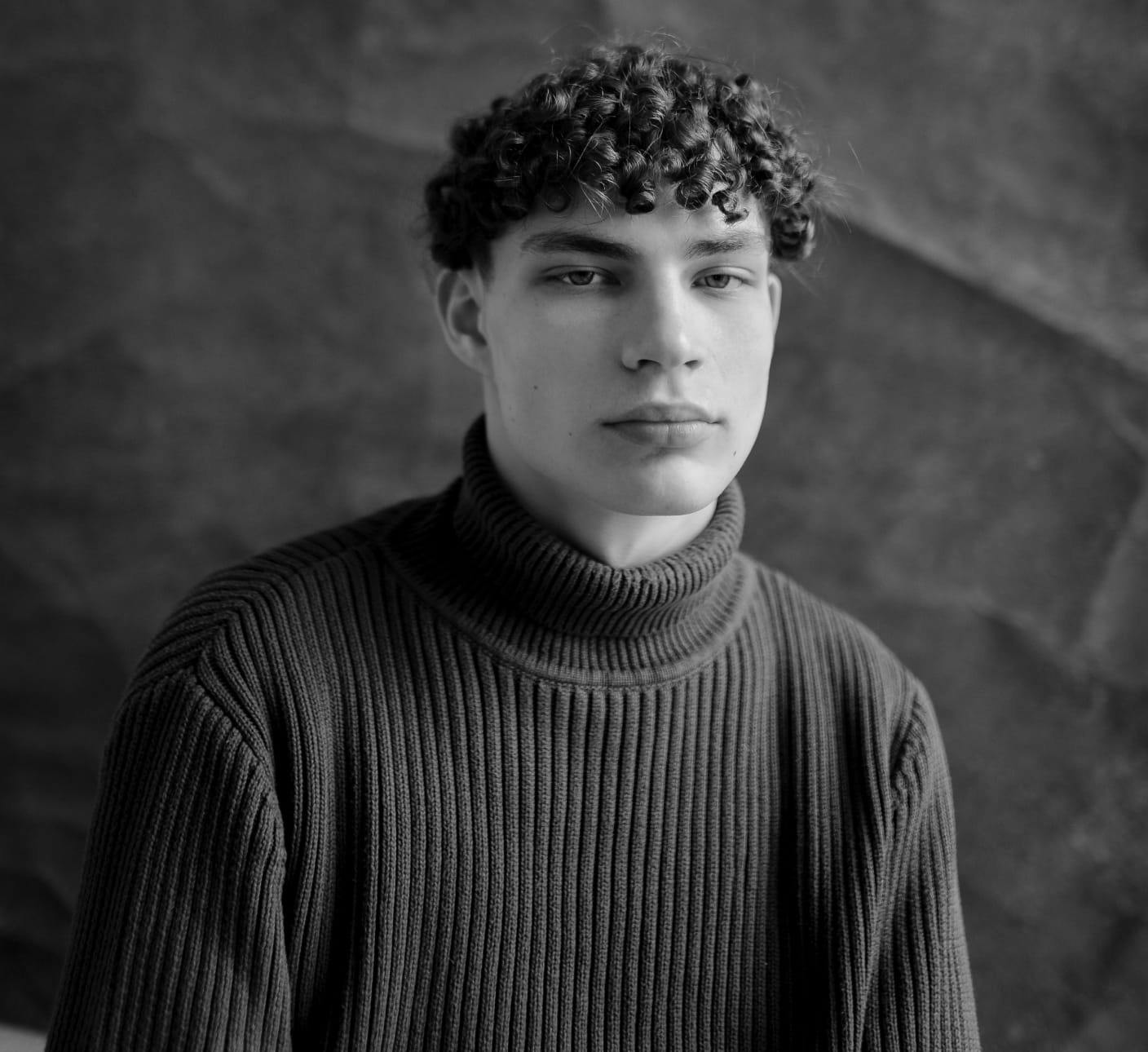 Black and white photo of a man with curly hair