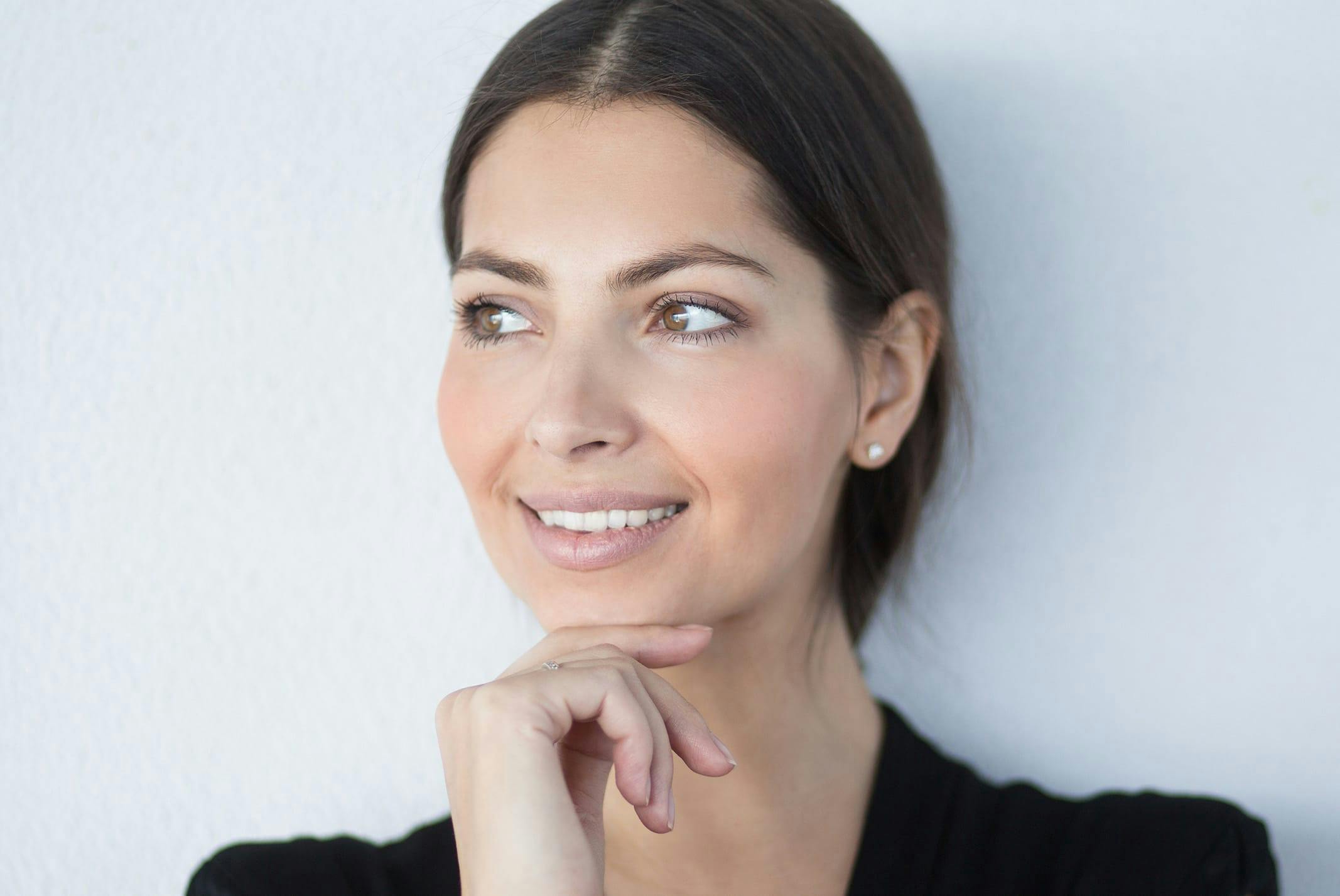 woman smiling with hand under chin