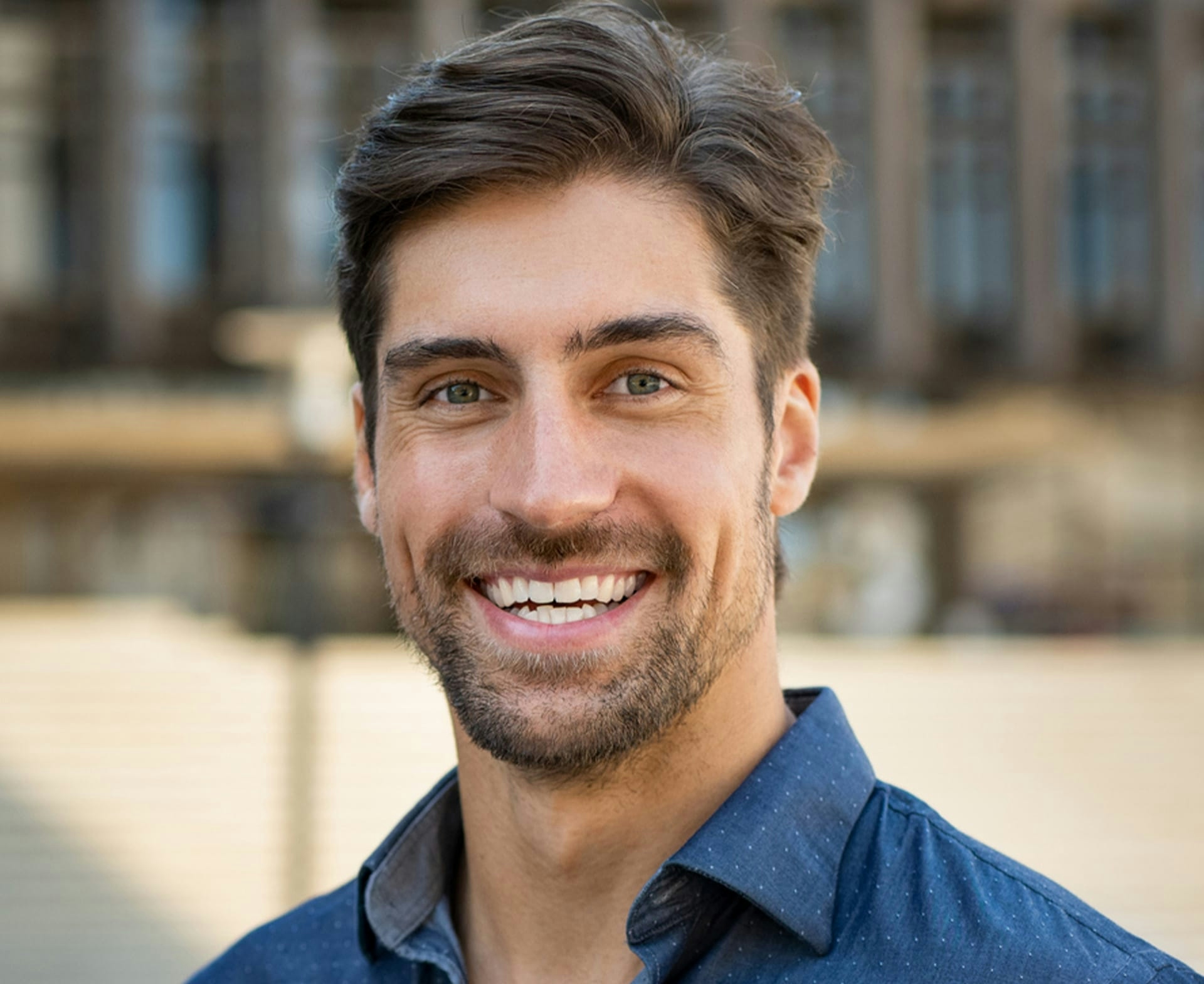 man smiling outside building