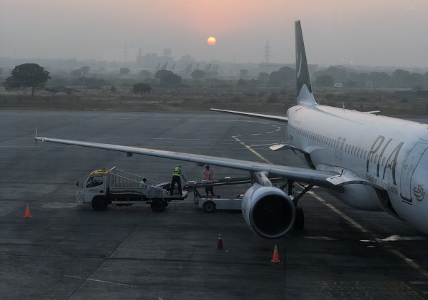 An elevated view of an airplane being unloaded of baggage