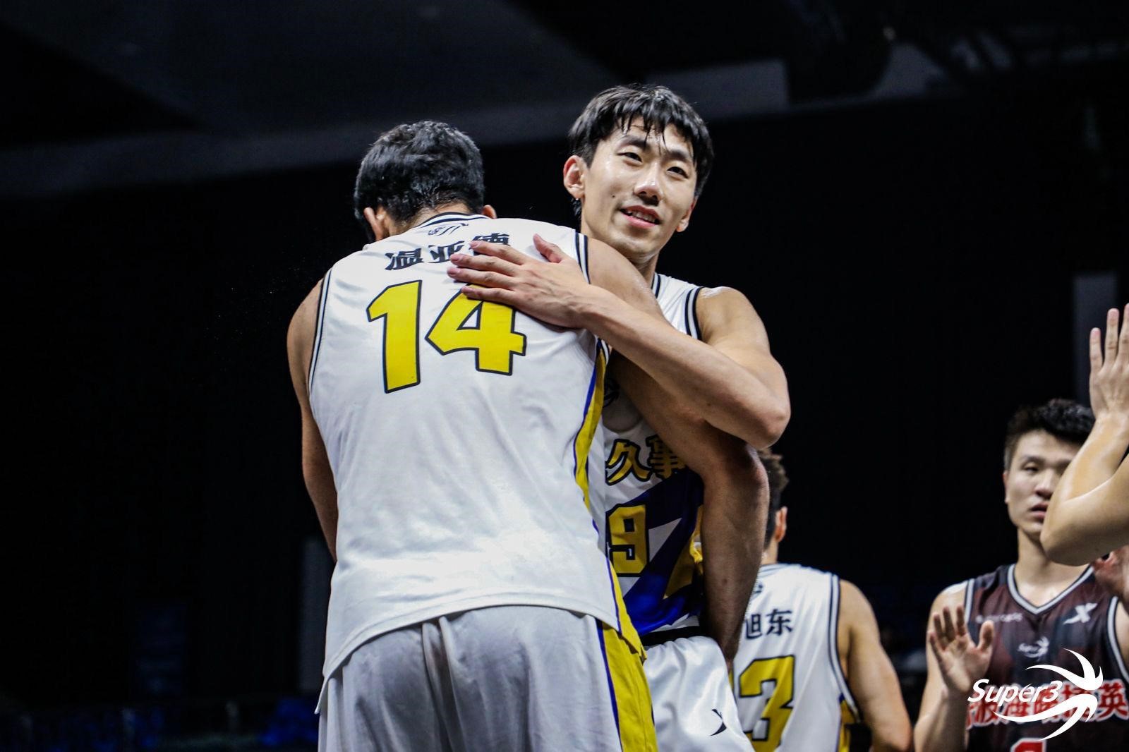 Two basketball players embrace on the court
