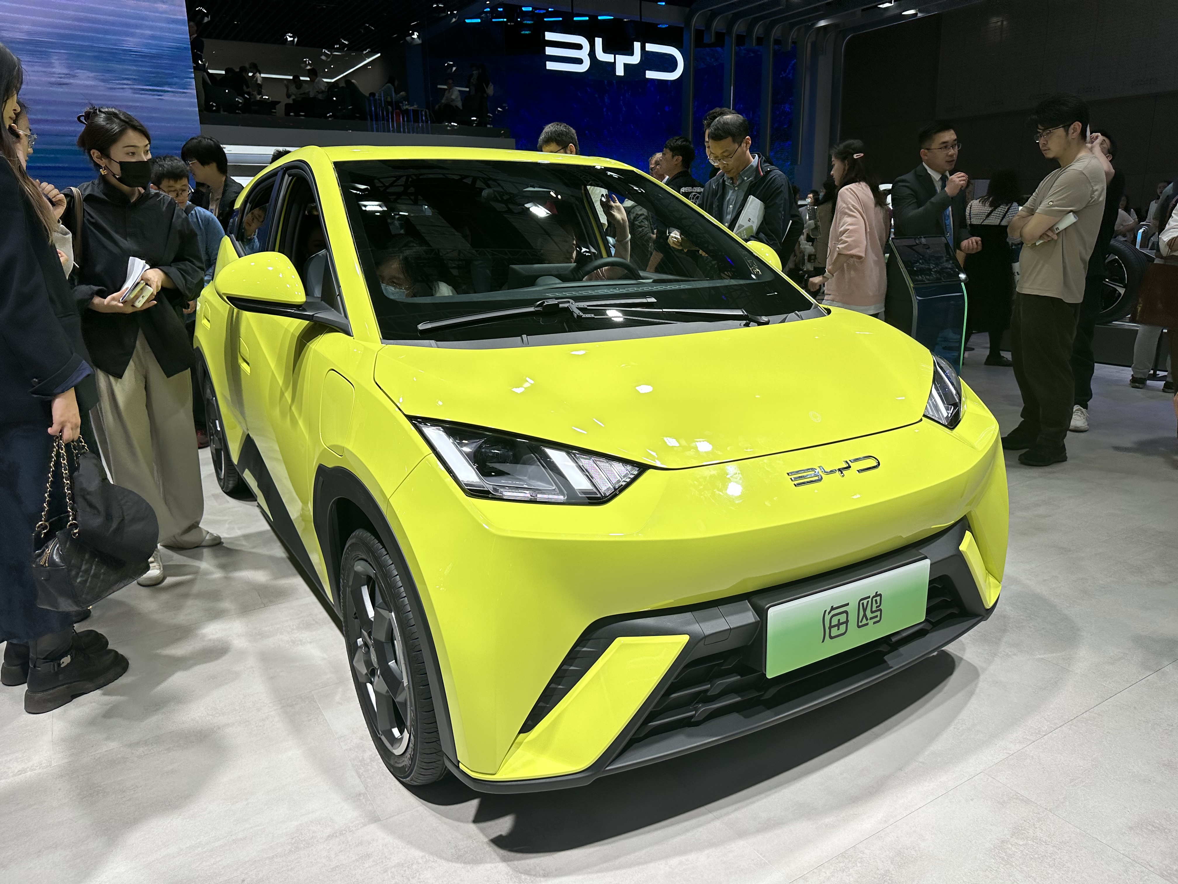 A bright yellow BYD vehicle on display at a car show