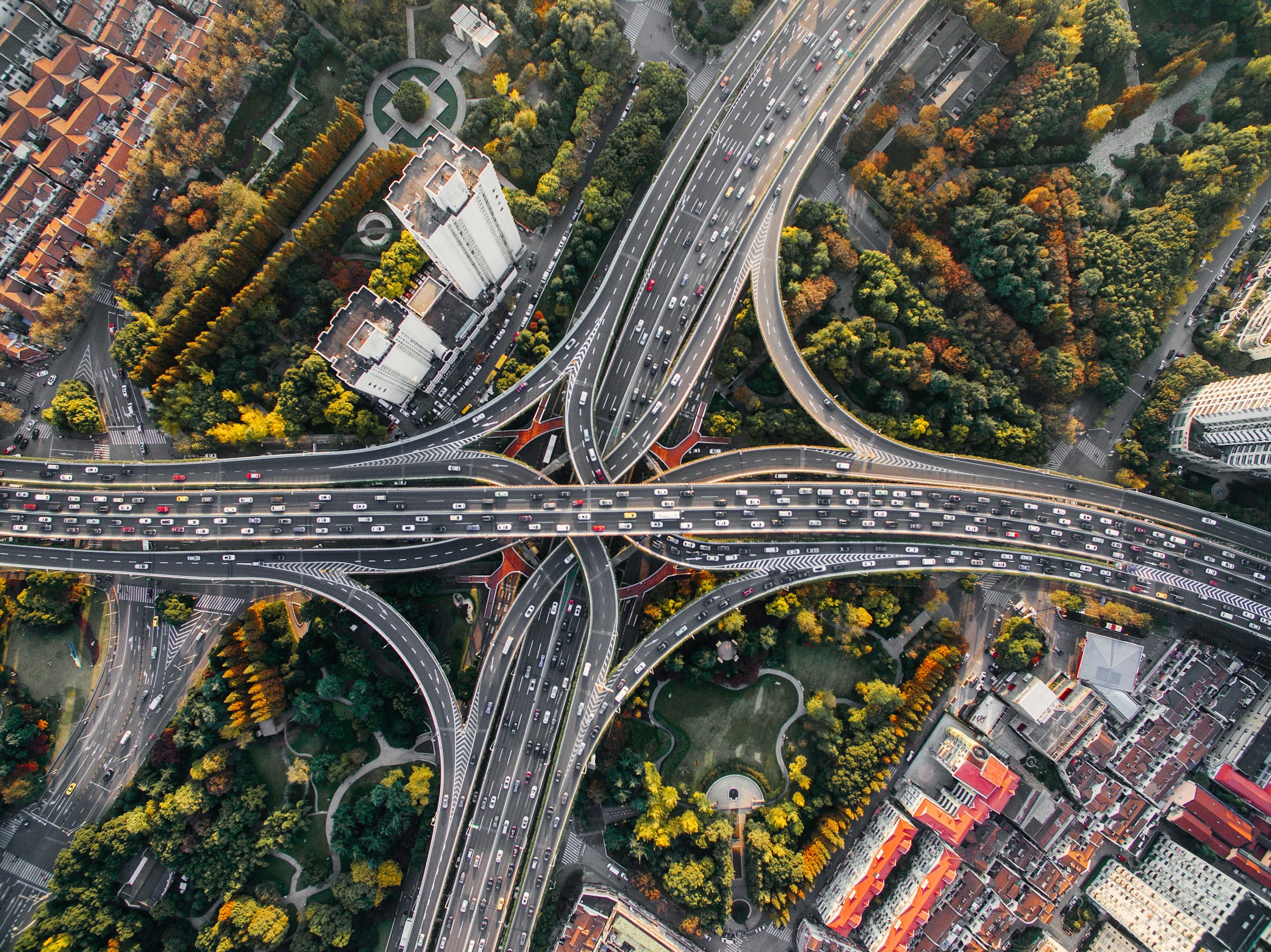A aerial view of several multi-lane roads merging at a four-way cross