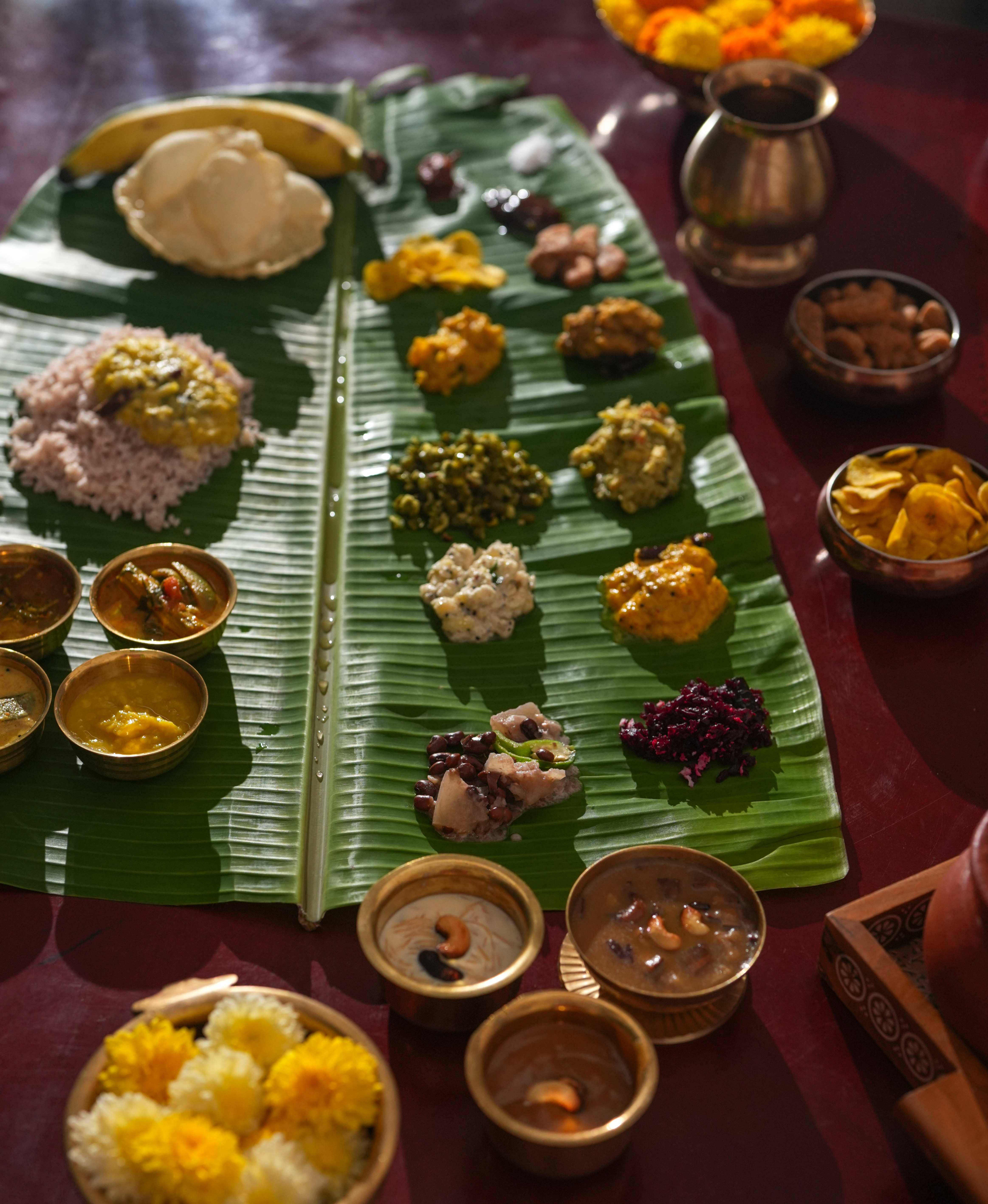 A selection of small dishes are laid out on a large banana leaf