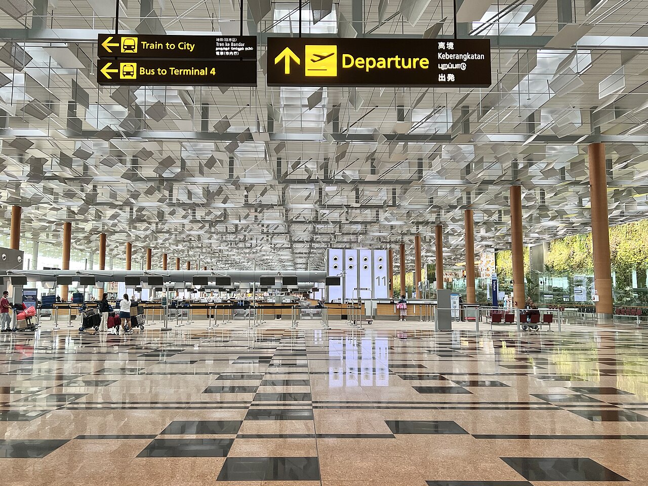 A shot of the interior of Changi Airport in Singapore, showing a huge open space and gleaming floors.