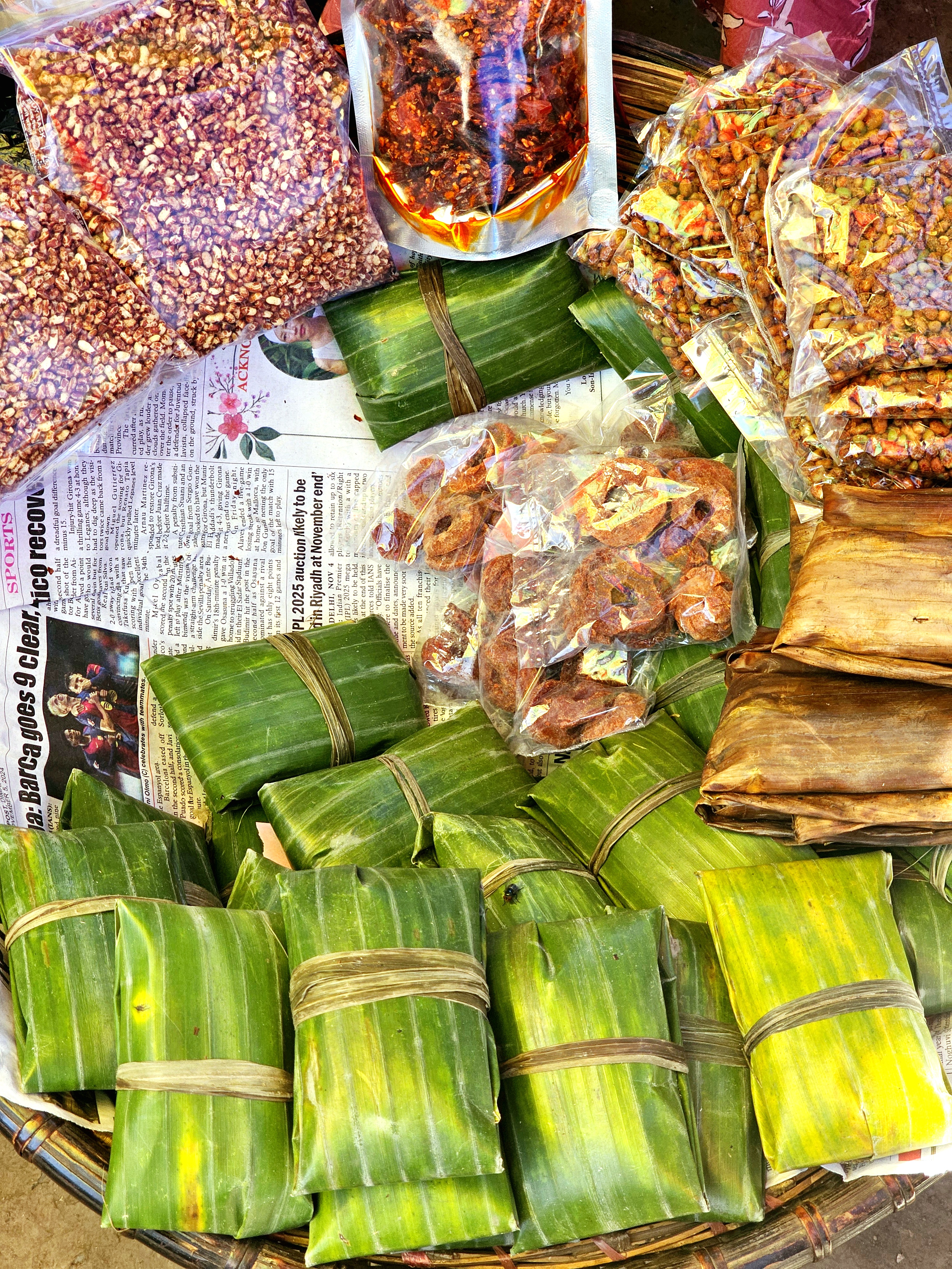 Bamboo wrapped packages are piled up next to plastic bags of spices