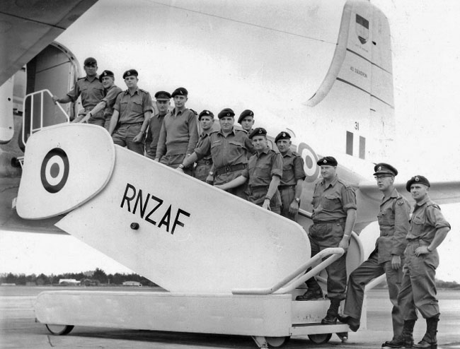 A black and white photo of Royal New Zealand Airforce personnel lined up to board a plane
