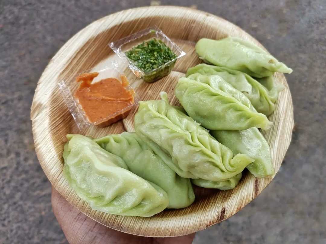 A pile of dumplings on a bamboo plate