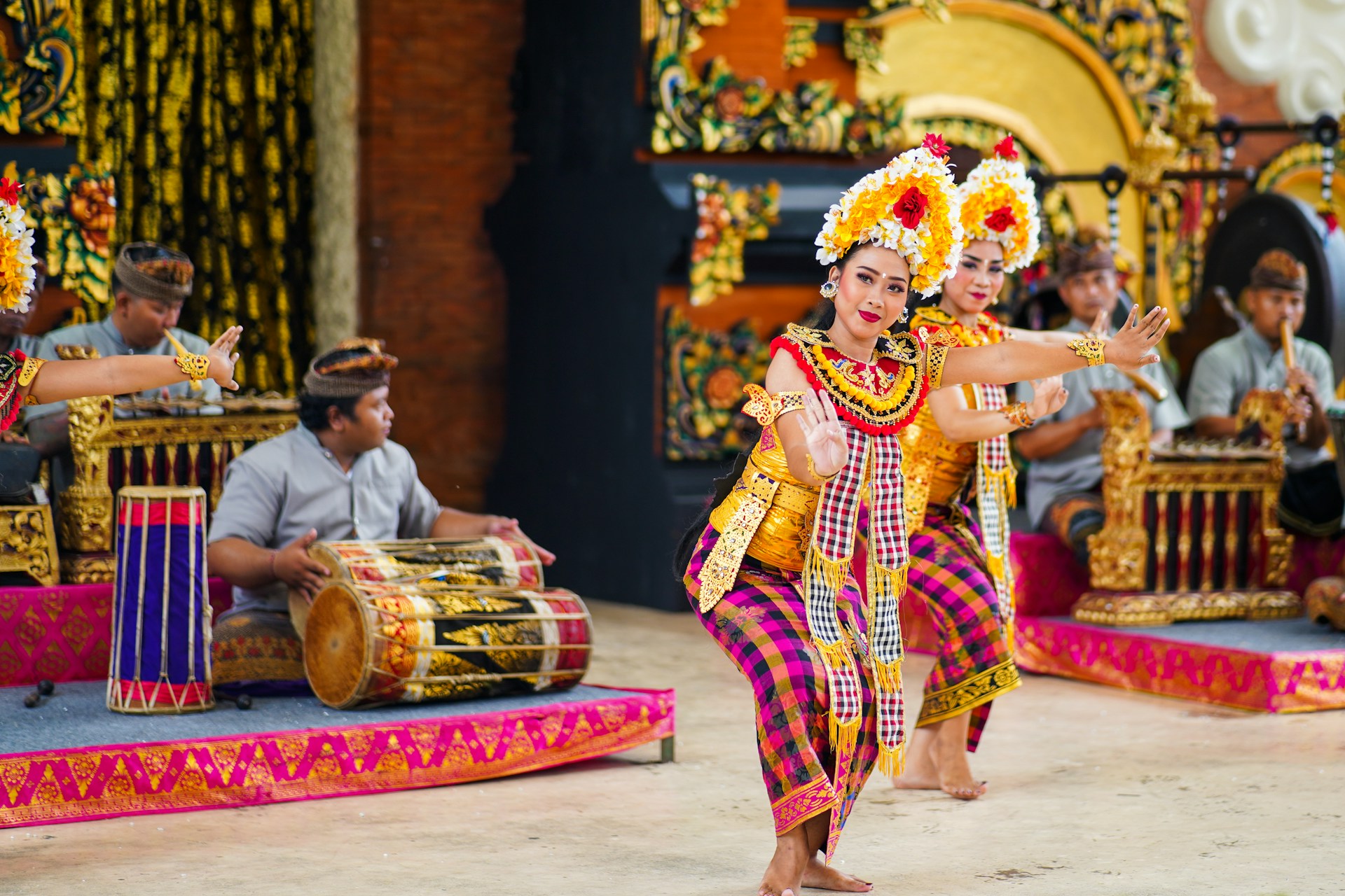 Women in red and yellow sari dresses perform a dance