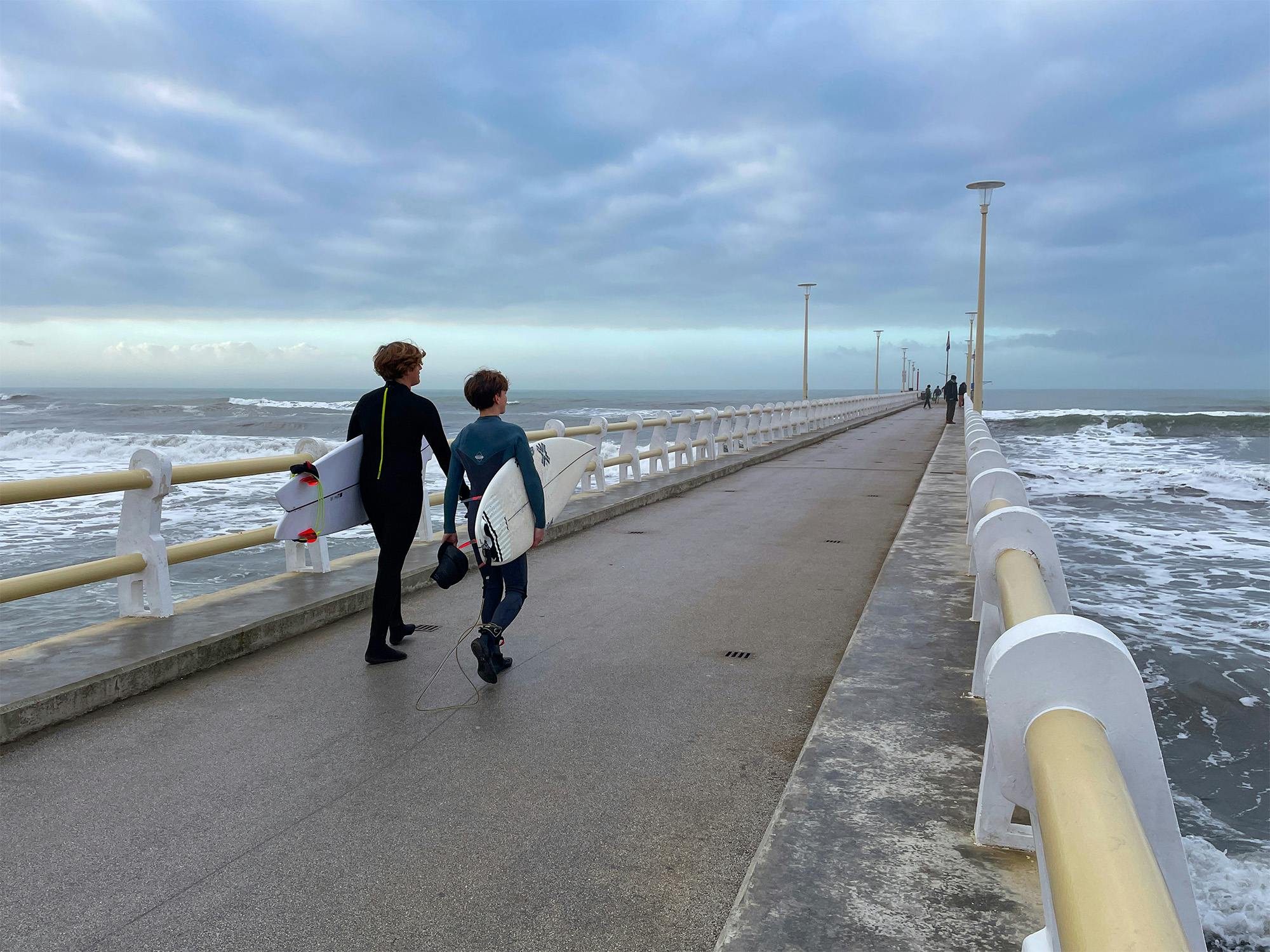 Giovani surfisti in inverno sul pontile di Forte dei Marmi