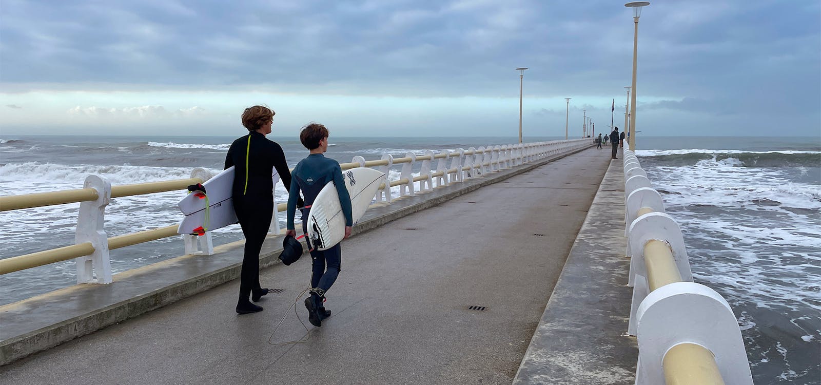 Giovani surfisti in inverno sul pontile di Forte dei Marmi Giovani surfisti in inverno sul pontile di Forte dei Marmi