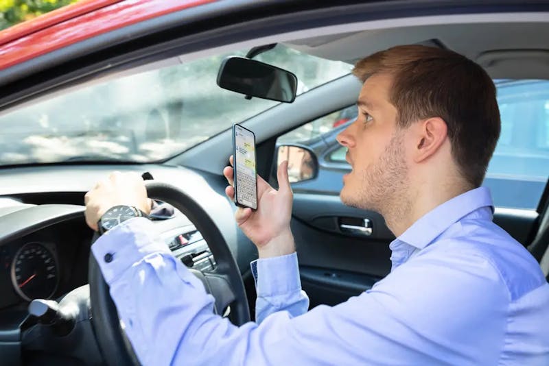 A person holding a phone in a car