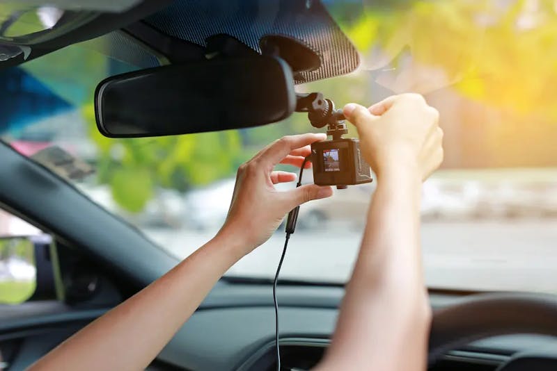 A person fixing a camera in the car