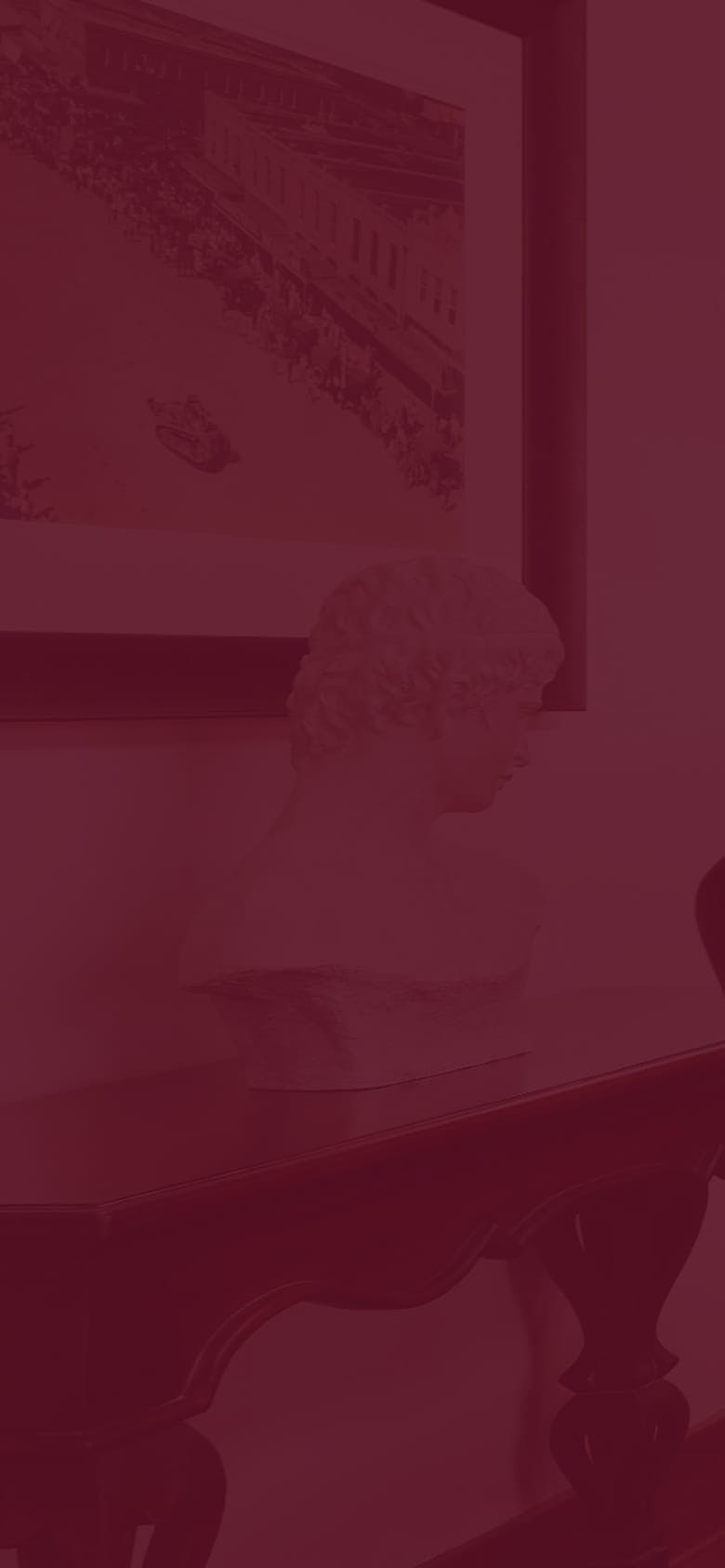 A statue on a small table up against a wall