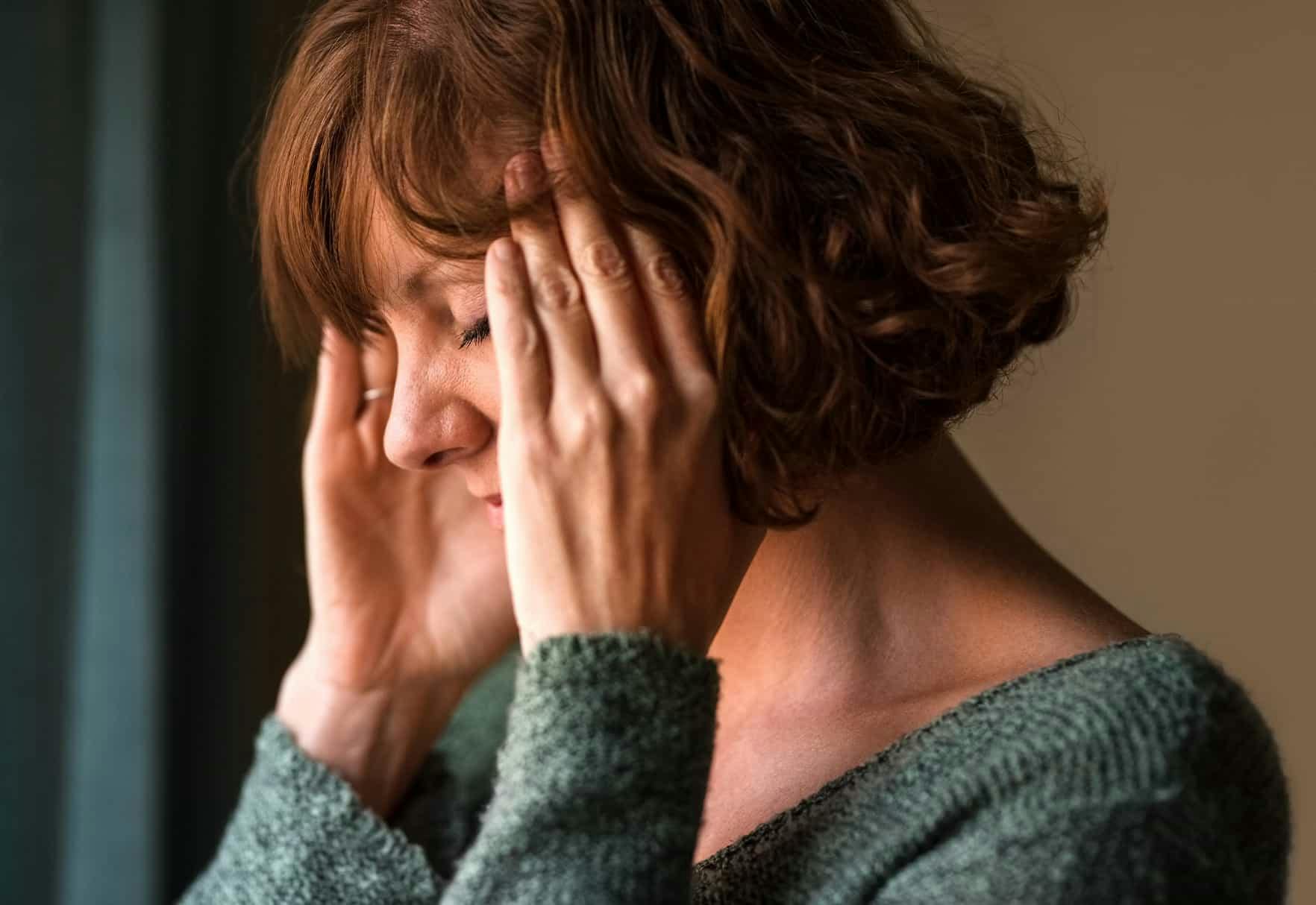 Woman holding head in pain