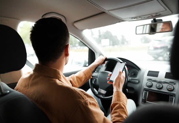Man holding phone while driving