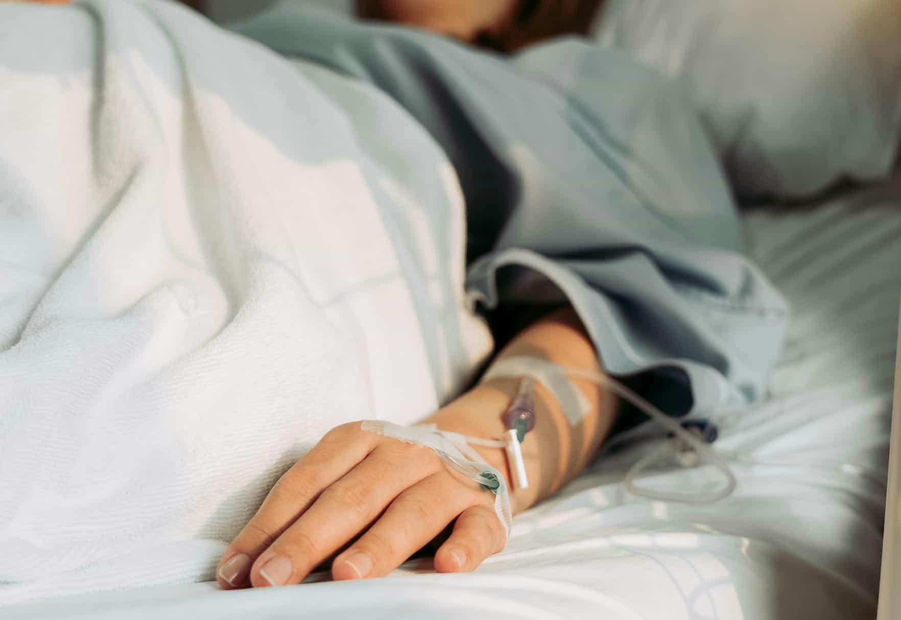 A peron with an IV in a medical bed
