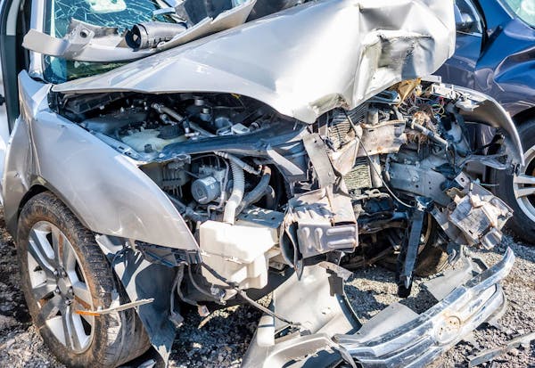 A completely damaged front end of a silver car