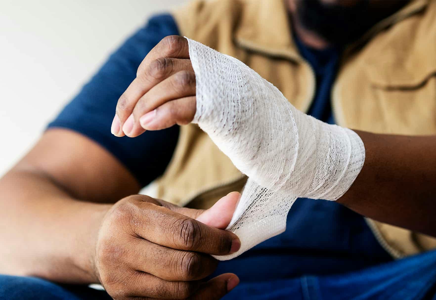 A man wrapping his hand in gauze