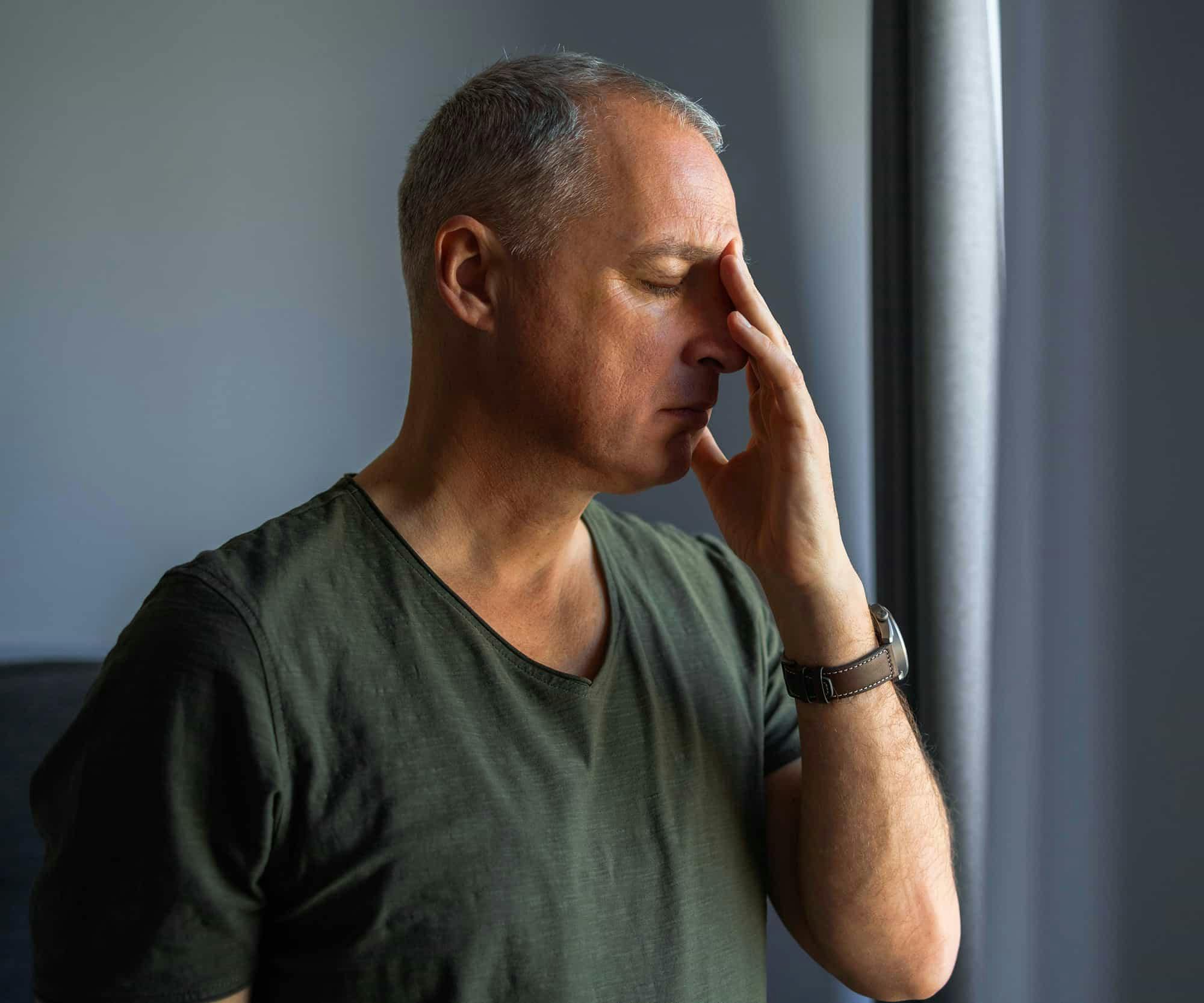 Man rubbing forehead in pain