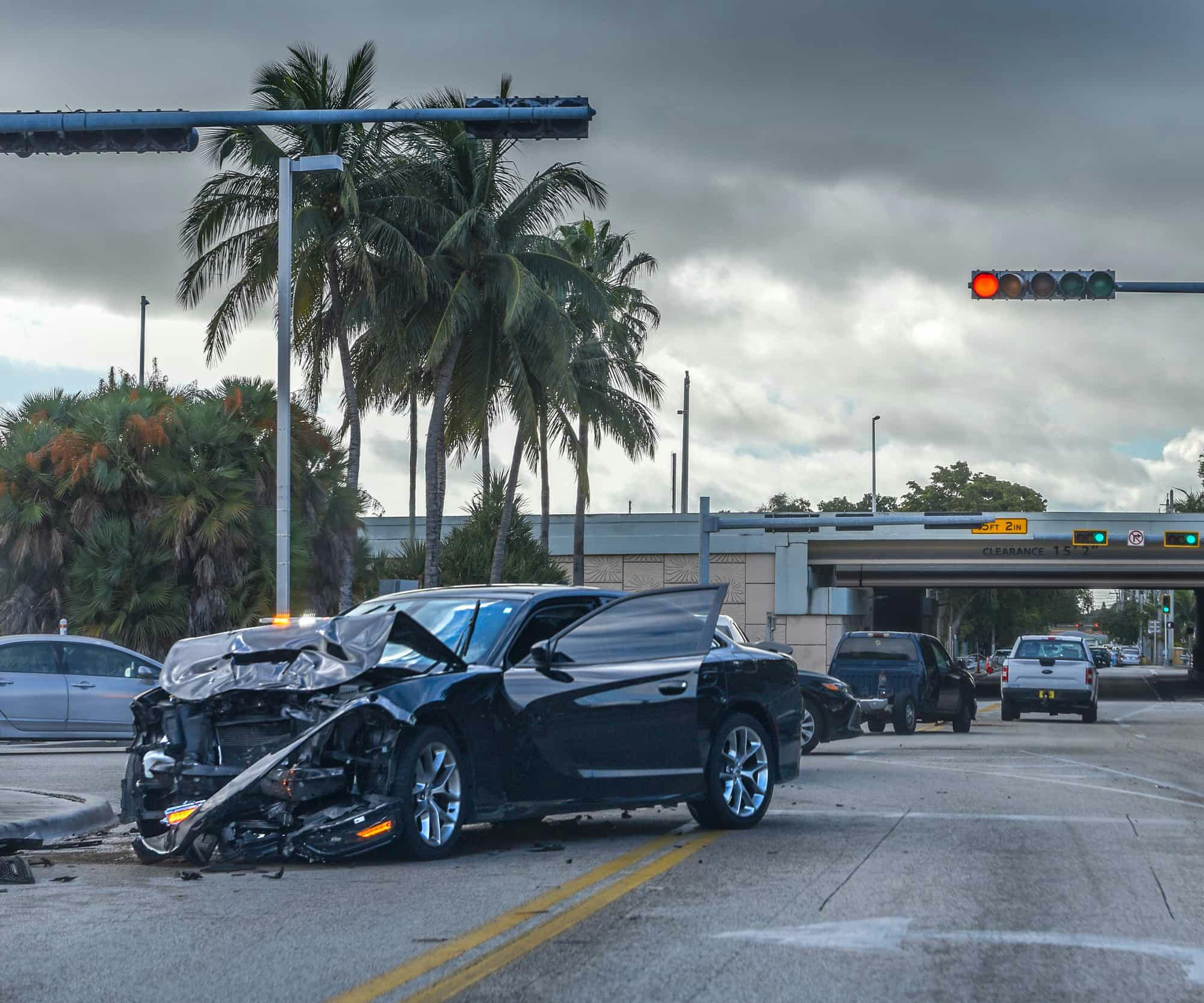 Destroyed front end of a car in the middle of the road