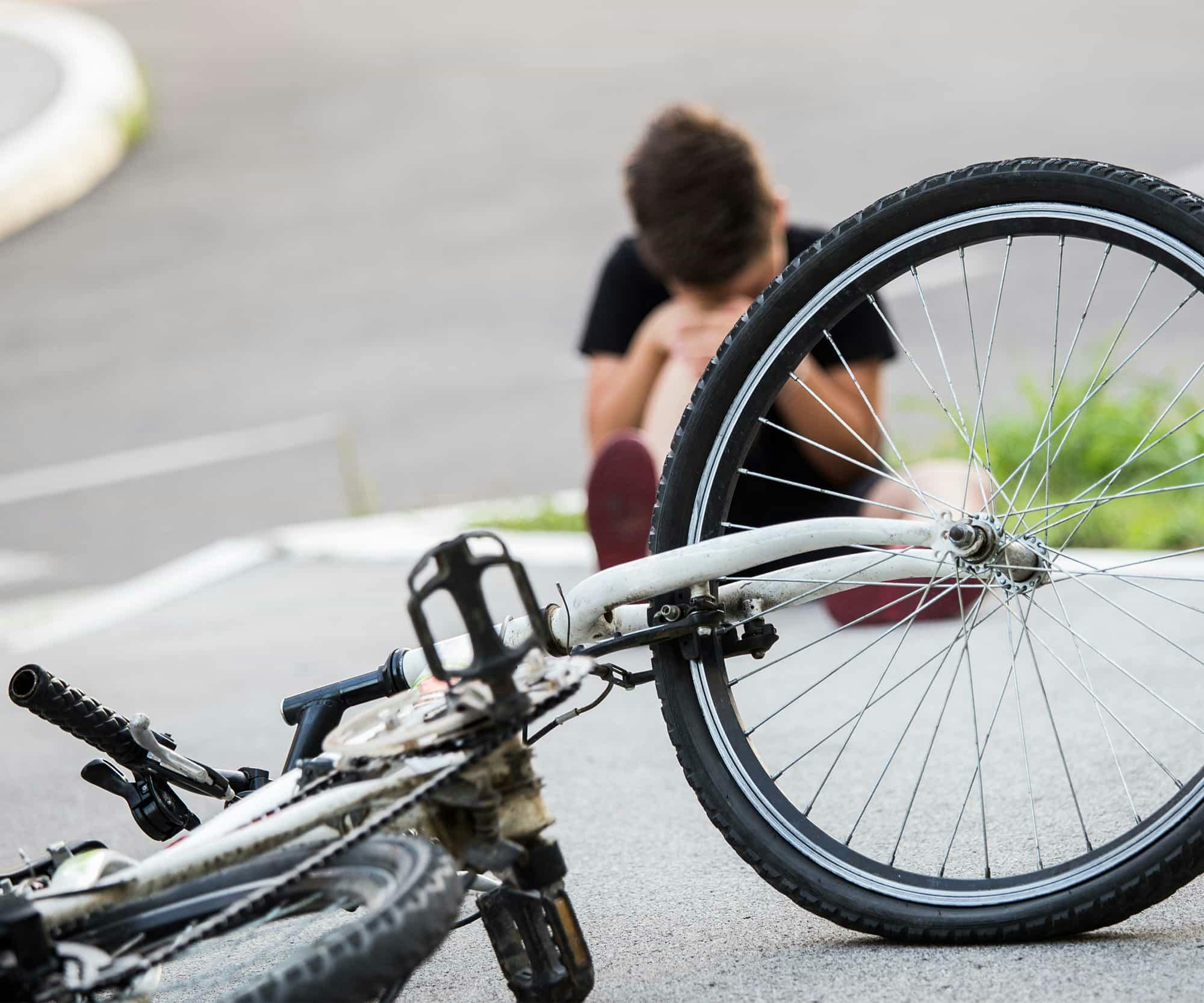 someone holding their knee after a bicycle accident