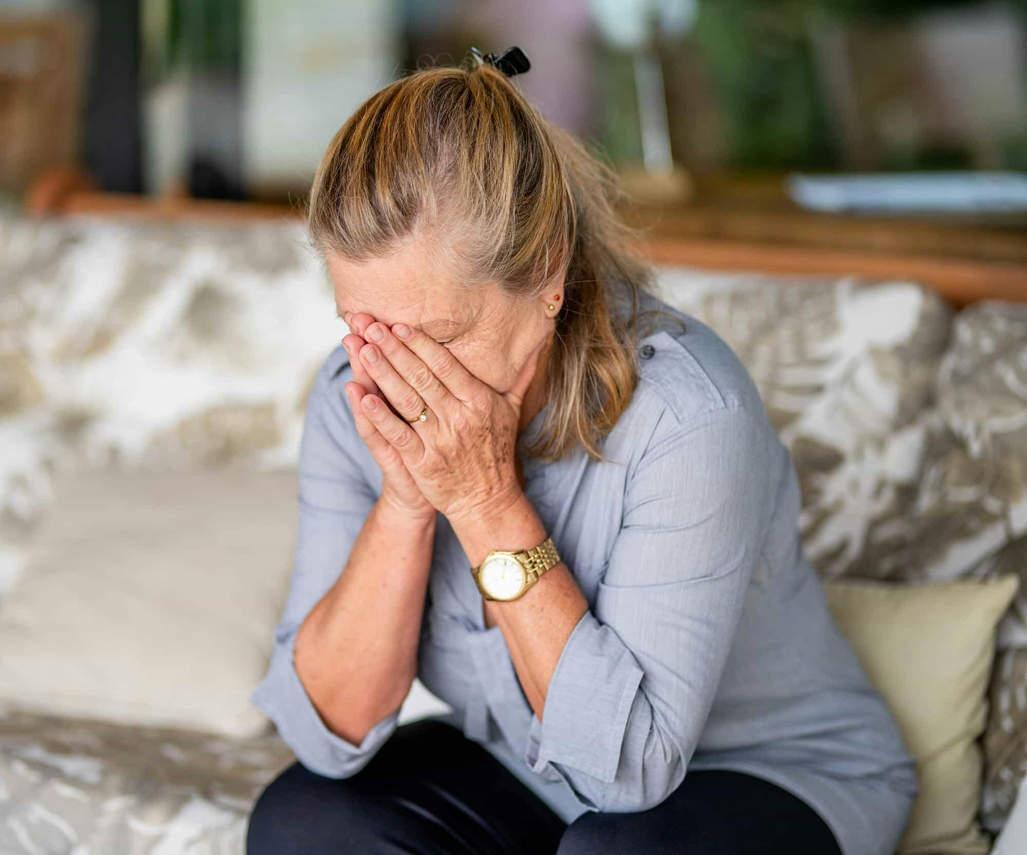 Woman with her face in her hands grieving