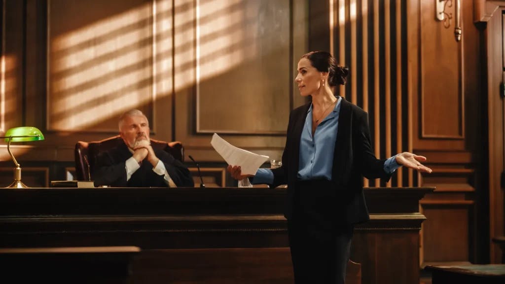 Attorney in front of a judge speaking to a courtroom.