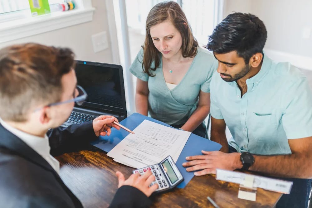 A couple speaking with their attorney and reviewing paperwork.