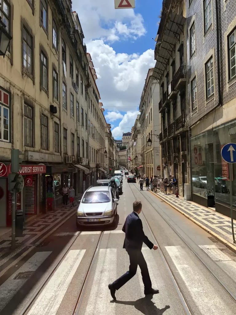 A man crossing a street with cars coming to him.