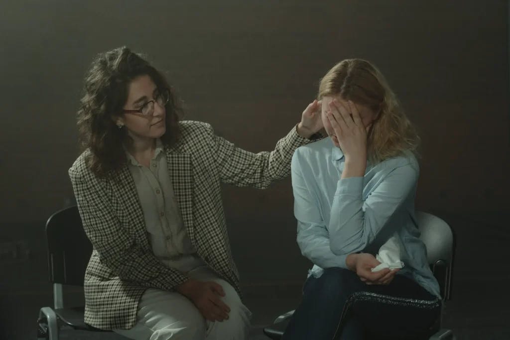 A woman consoling another woman in a support group.