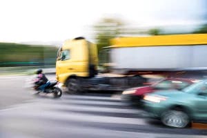 A semi-truck speeding by out of control because the truck had not been properly maintained.