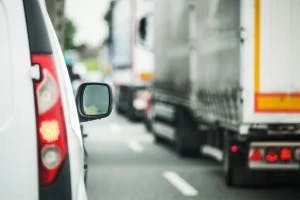 A line of semi trucks on the road. Some drivers wonder who is responsible for compensation if injured in a truck accident.