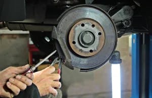 A mechanic working on a truck brakes.