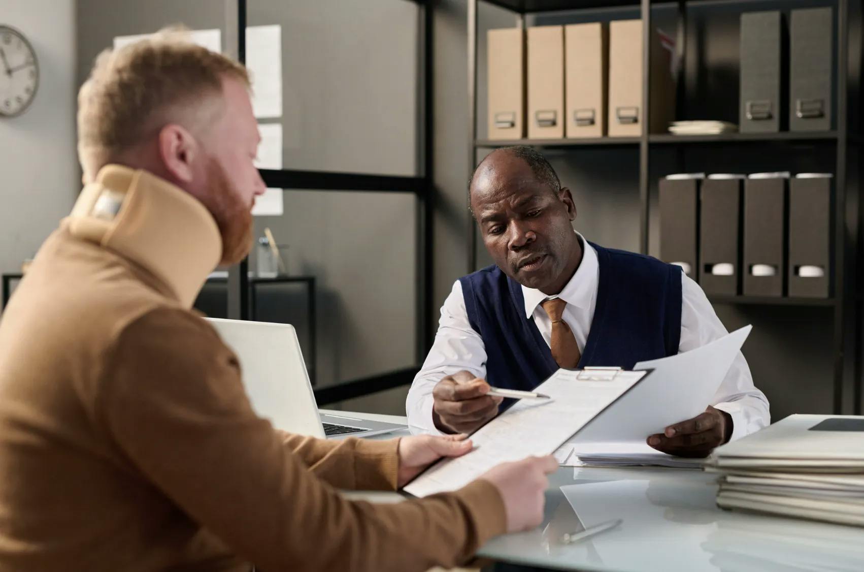 injury lawyer showing his client some papers.