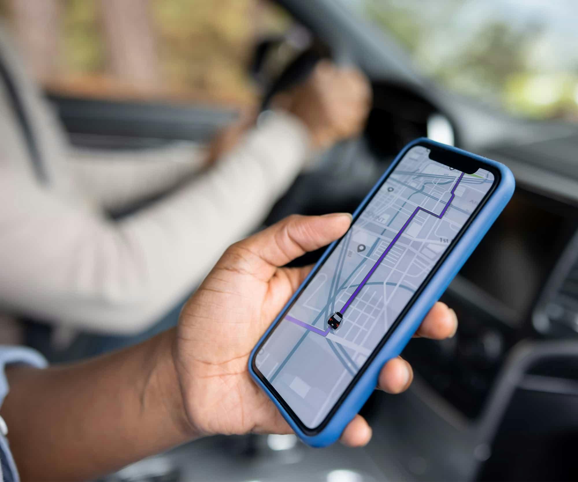 A person in the passenger seat of a car looking at the maps app