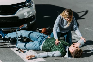 An injured man laying on the street getting help